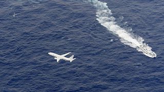 Image: A Japan Coast Guard patrol vessel and U.S. Navy airplane conduct sea