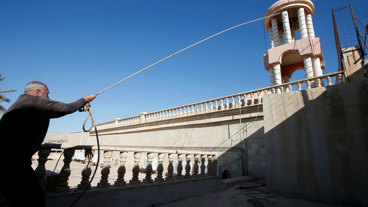 Restoring faith: Crucifix replaced above newly-liberated Bashiqa church in Iraq