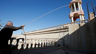 Restoring faith: Crucifix replaced above newly-liberated Bashiqa church in Iraq