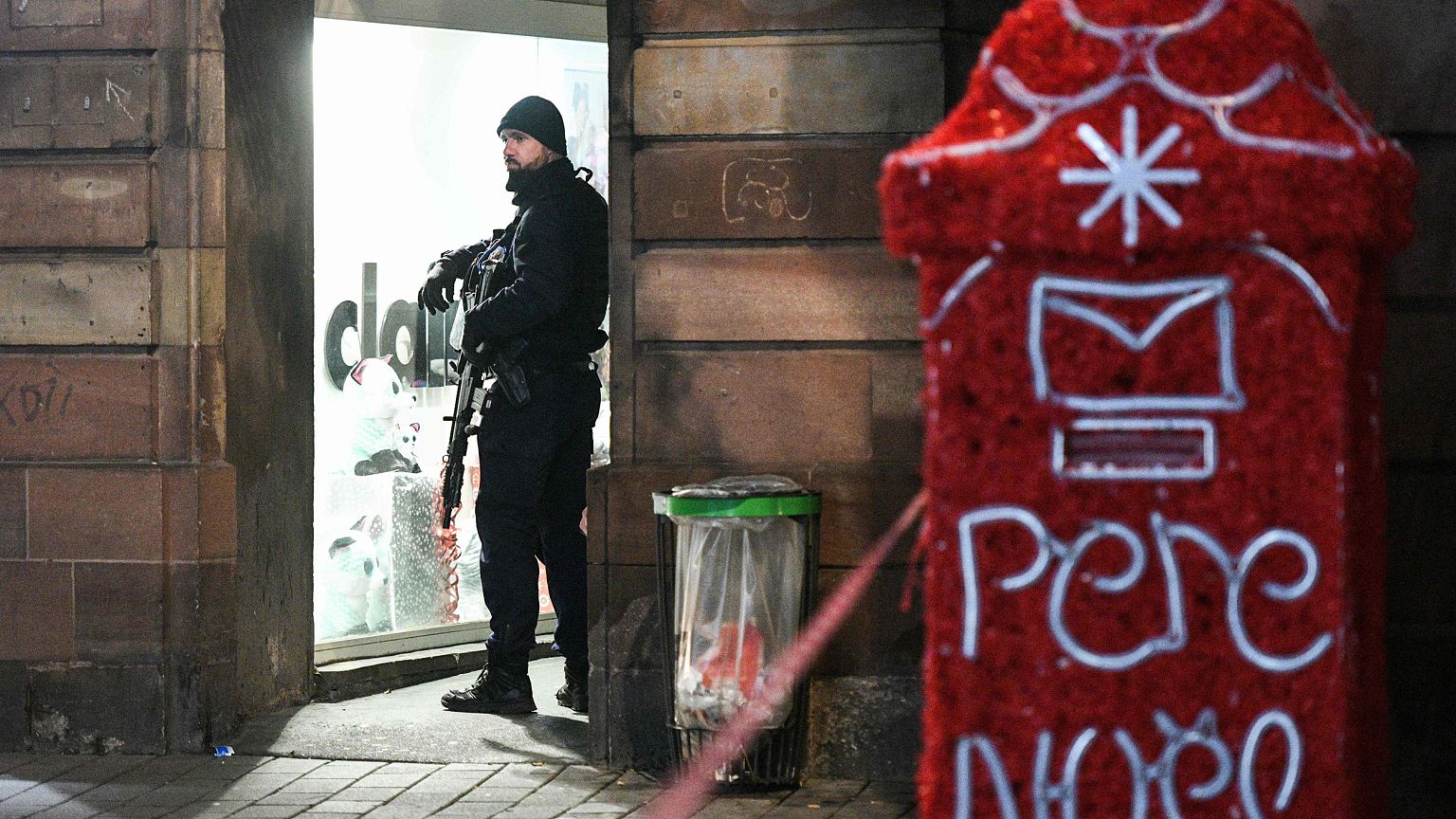 Image: A French CRS policeman stands guard while searches are conducted