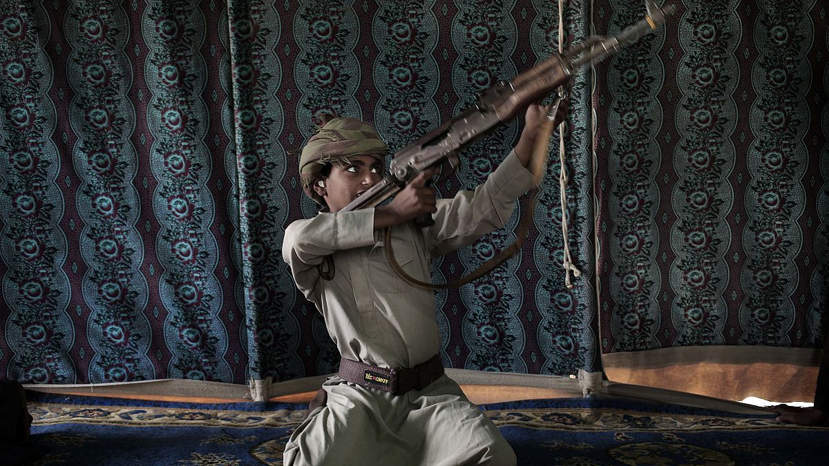 Image: Kahlan, a 12-year-old former child soldier, demonstrates how to use 