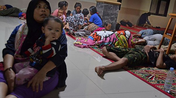 Image: Residents sit inside a mosque as they evacuated following high waves Image: Residents sit inside a mosque as they evacuated following high waves