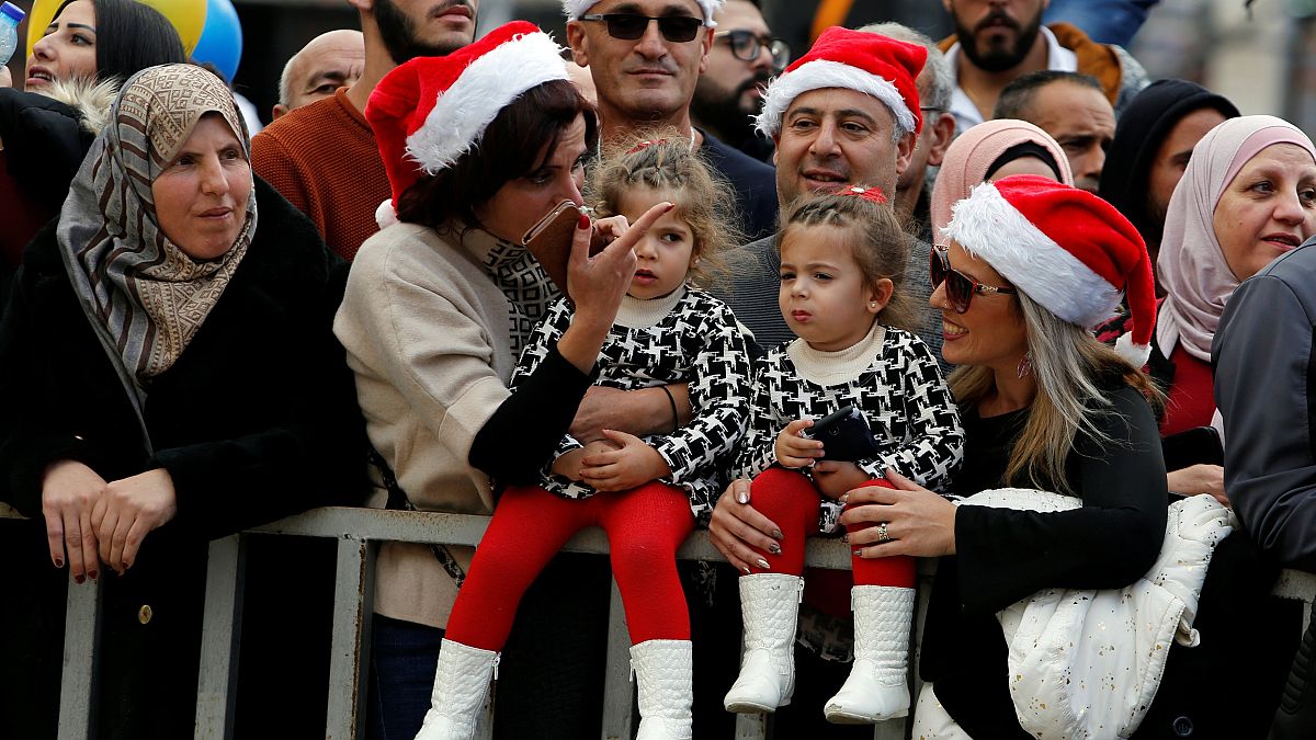 Image: People attend Christmas celebrations at Manger Square outside the Ch