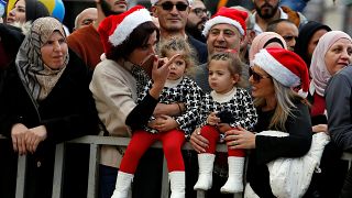 Image: People attend Christmas celebrations at Manger Square outside the Ch