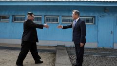 Image: Kim Jong Un and Moon Jae-in shake hands over the military demarcatio