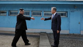 Image: Kim Jong Un and Moon Jae-in shake hands over the military demarcatio