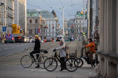 Bicyclists wait to cross the street in Vienna.
