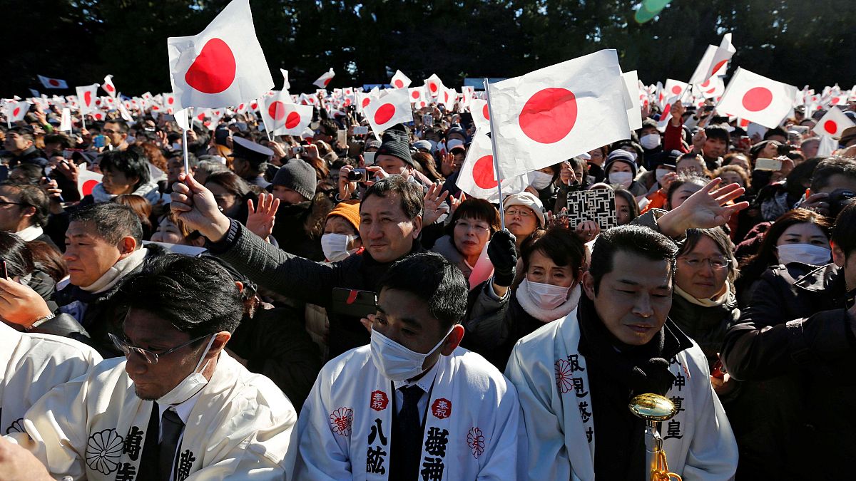 Image: Cheering crowds greet Japan's Emperor Akihito and other members of t