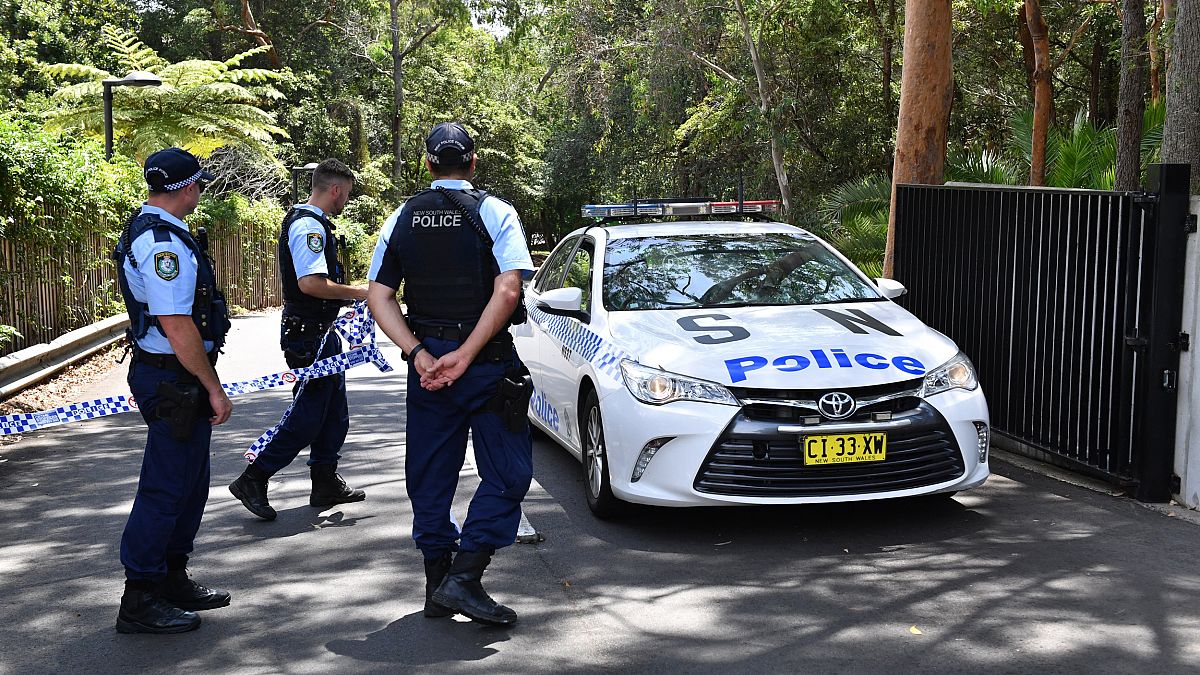 Image: New South Wales police stand guard at the scene of a stabbing at the