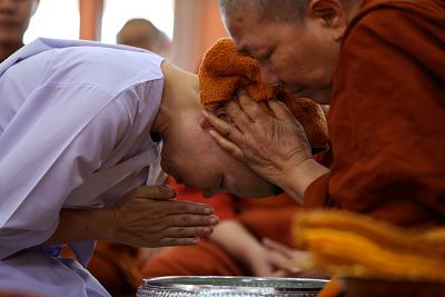 A devotee has her head cleaned by Dhammananda Bhikkhuni, the abbess at Songdhammakalyani monastery.