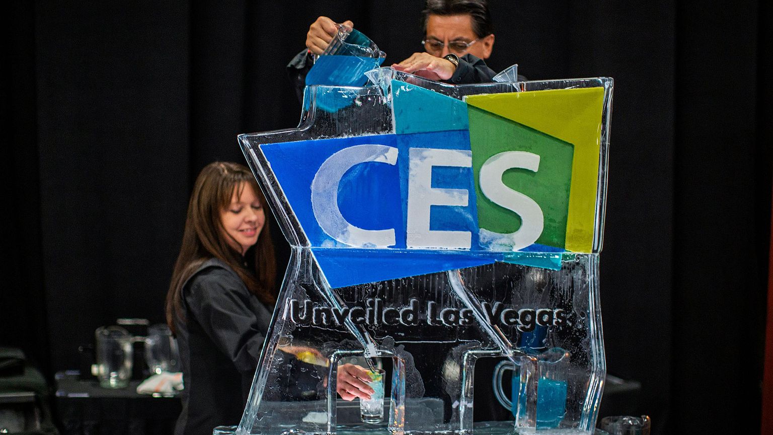 Image: Workers serve beverages from an ice sculpture during the Consumer El