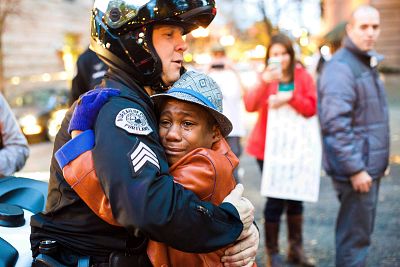Portland police Sgt. Bret Barnum, left, and Devonte Hart, 12, hug at a rally in Portland, Oregon, where people gathered in support of the protests in Ferguson, Missouri.