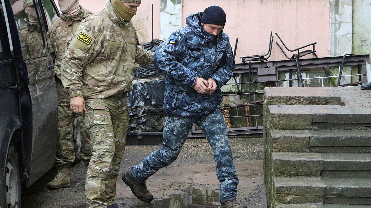 Image: A member of Russia's FSB security service escorts a detained Ukraini