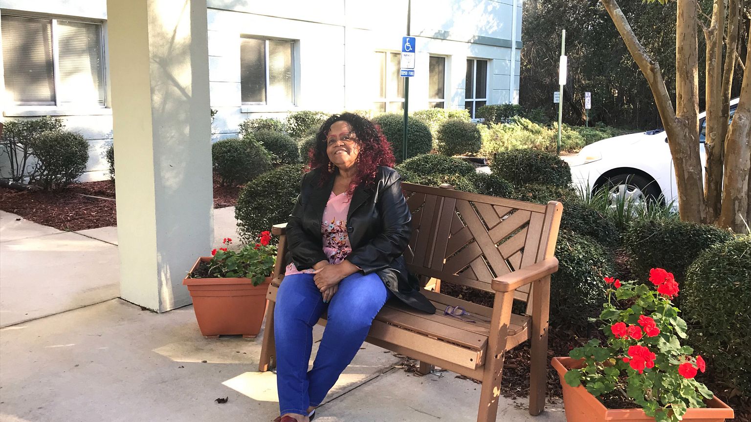Photography of Shirley Henderson in front of her apartment building.