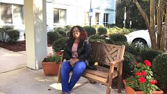 Photography of Shirley Henderson in front of her apartment building.