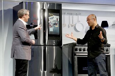 John Herring and Yoon Lee, executives with Samsung Electronics America, post a photo to "Family Board" on a  Family Hub smart refrigerator during a Samsung news conference at the 2019 CES in Las Vegas on Jan. 7, 2019.