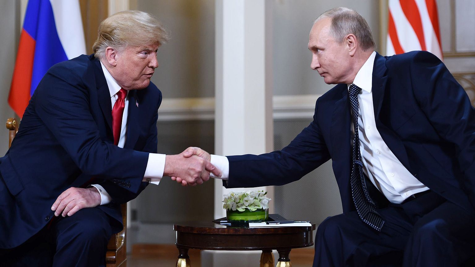 Image: Vladimir Putin  and Donald Trump shake hands before a meeting in Hel