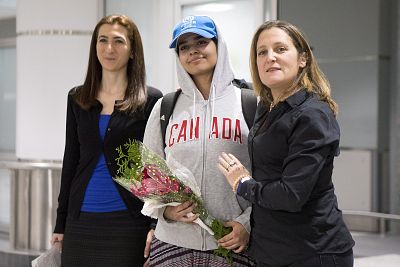 Rahaf Mohammed Alqunun, 18, center, stands with Canadian Minister of Foreign Affairs Chrystia Freeland, right, as she arrives at Toronto Pearson International Airport, on Jan.12, 2019.