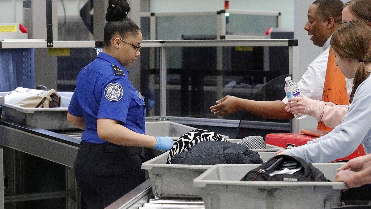 Image: A Transportation Security Administration employee helps air traveler