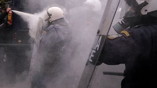 Image: A protester uses a fire extinguisher against riot police during clas