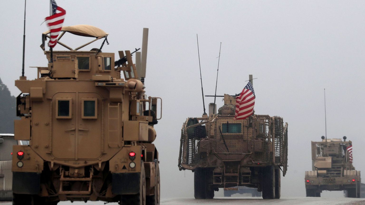 Image: A line of US military vehicles in Syria's northern city of Manbij