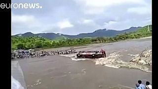Watch: Passengers trapped after bus overturns into swollen river in Peru