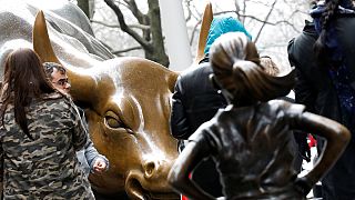 Una niña frente al toro de Wall Street como símbolo del Día de la Mujer