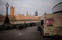 Image: A street cleaner walks near the Houses of Parliament