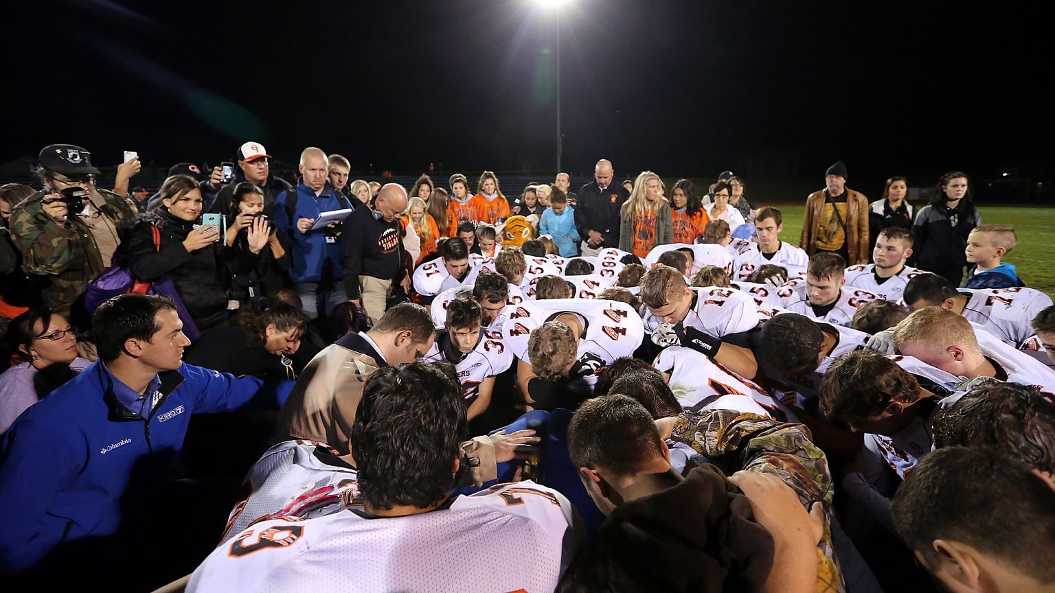 Image: Bremerton assistant football coach Joe Kennedy, obscured at center i