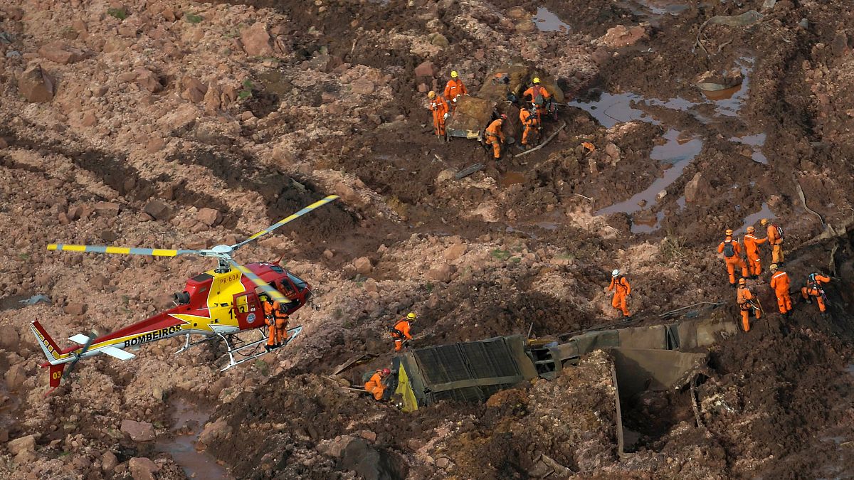 Image: Rescue crew work in a dam owned by Brazilian miner Vale SA that burs