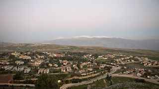 Image: The town of Metula with Mt. Hermon in the background