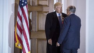 Image: Then-President-elect Donald Trump talks with Rudy Giuliani after a m