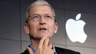 Image: Apple CEO Tim Cook responds to a question during a news conference