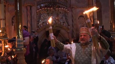 Cristãos acendem velas com fogo sagrado