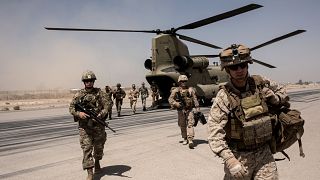 Image: U.S. troops walk off a helicopter at Camp Bost in Helmand Province,
