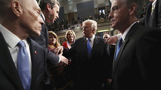 Image: Trump shakes hands as he leaves after delivering his first State of 