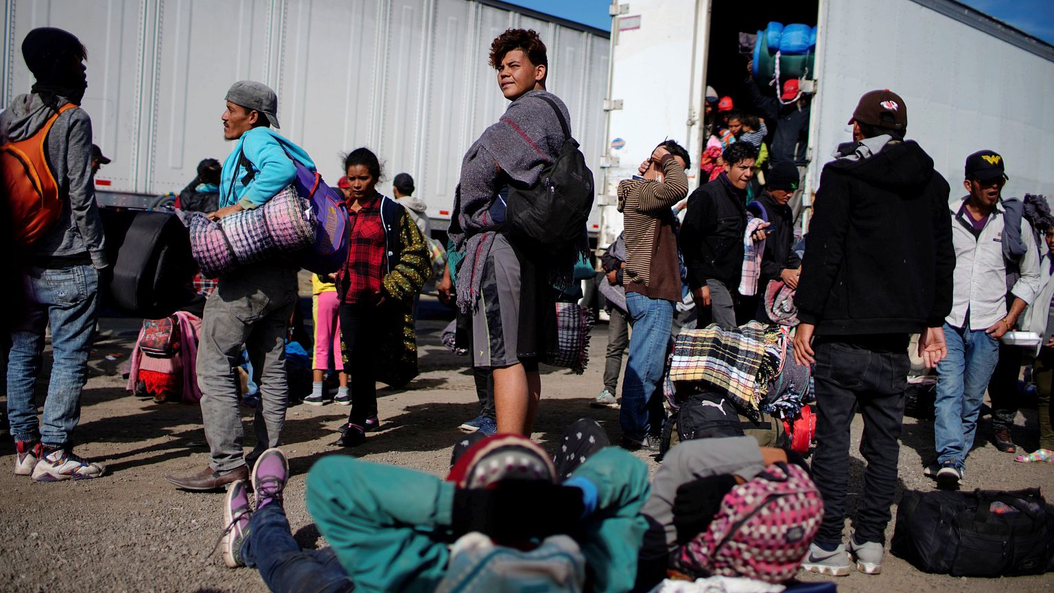 Image: Migrants rest beside a highway during their journey to the United St