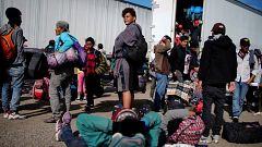Image: Migrants rest beside a highway during their journey to the United St