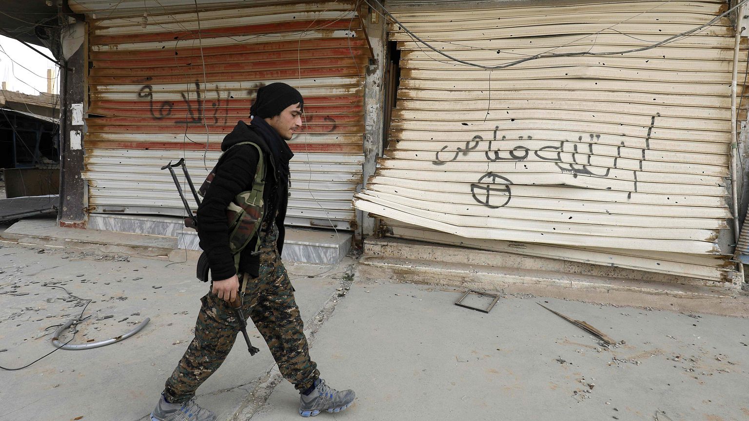 Image: A fighter from the U.S.-backed Syrian Democratic Forces in Hajin, Sy