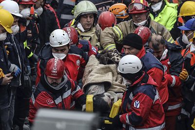 Turkish rescue workers carry a 16-year-old boy after they pulled out him from the rubble from an eight-story building which collapsed two days earlier in Istanbul on Feb. 8, 2019.