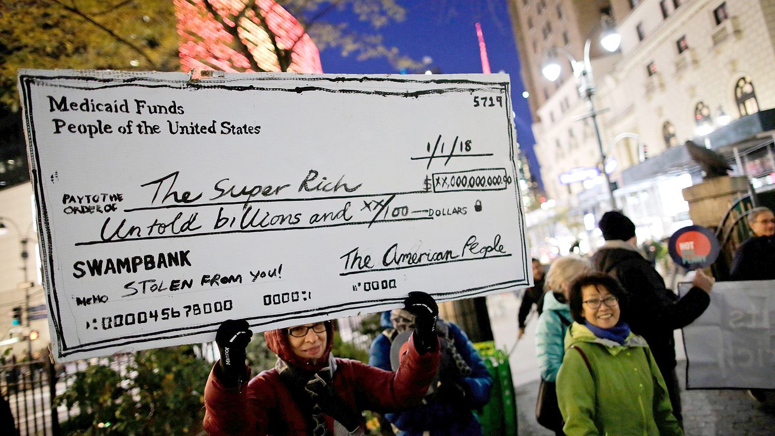 Image: Demonstrators take part in a protest against tax cuts for rich peopl