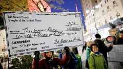 Image: Demonstrators take part in a protest against tax cuts for rich peopl