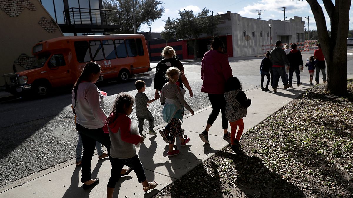 Image: Immigrants walk to an aid center after being released from governmen