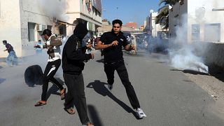Image: Bahraini protestors run for cover after