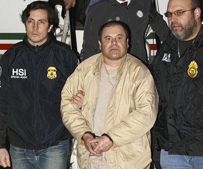 Authorities escort Joaquin "El Chapo" Guzman, from center, from a plane to a waiting caravan of SUVs at Long Island MacArthur Airport in Ronkonkoma, N.Y. on Jan. 19, 2017.