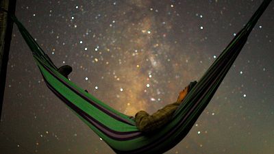 A girl lies in hammock as she looks at the milky way during the peak of Per