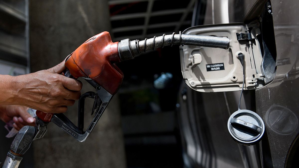 Image: An employee pumps gas into a car in Caracas, Venezuela, on Aug. 17, 