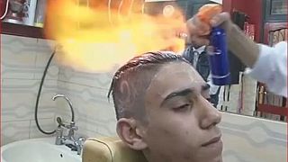 Un coiffeur égyptien défrise les cheveux avec du feu
