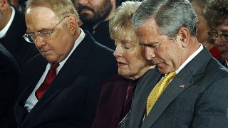 Image: President George W. Bush bows his head in prayer along with Dr. Jame