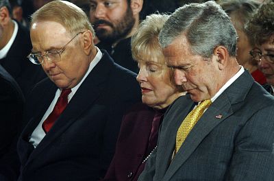 President George W. Bush bows his head in prayer along with Dr. James Dobson, left, during the National Day of Prayer ceremony at the White House in 2007.